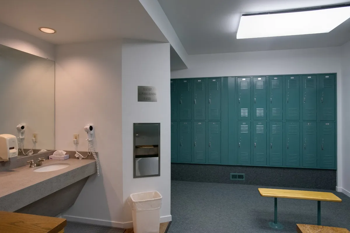An entryway-style locker room interior including a sink with mirror, a row of lockers, and a wooden bench—offering both utility and a welcoming transition space for returning skiers. The space feels practical and designed for comfort after a day on the mountain.